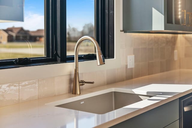 7284 205th St W, Faribault, MN 55021 - details featuring tasteful backsplash, gray cabinetry, a sink, and light countertops