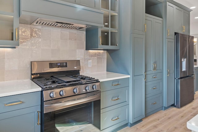 7284 205th St W, Faribault, MN 55021 - kitchen featuring backsplash, under cabinet range hood, light wood-style floors, and stainless steel appliances
