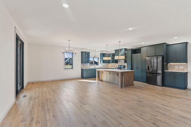 7284 205th St W, Faribault, MN 55021 - kitchen featuring stainless steel refrigerator with ice dispenser, light countertops, backsplash, and custom range hood