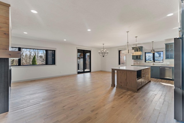 7284 205th St W, Faribault, MN 55021 - kitchen with light countertops, a healthy amount of sunlight, a kitchen island, appliances with stainless steel finishes, and a notable chandelier