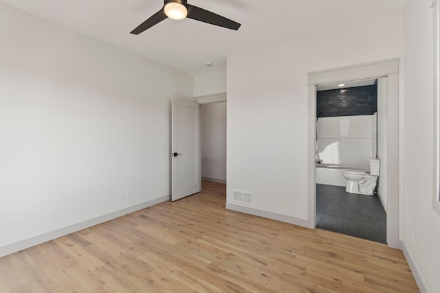 7284 205th St W, Faribault, MN 55021 - unfurnished bedroom with baseboards, ensuite bathroom, visible vents, and light wood-type flooring