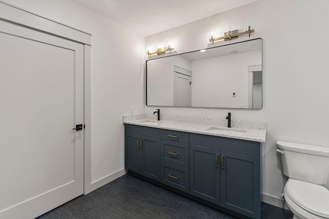 7284 205th St W, Faribault, MN 55021 - bathroom with double vanity, toilet, baseboards, and a sink