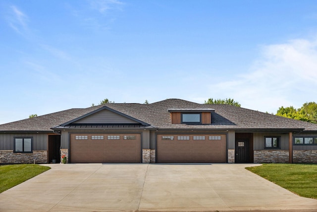 7284 205th St W, Faribault, MN 55021 - view of front of property featuring driveway, a garage, stone siding, a front lawn, and a shingled roof