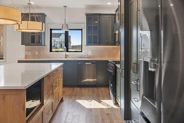7284 205th St W, Faribault, MN 55021 - kitchen with appliances with stainless steel finishes, hardwood / wood-style flooring, decorative backsplash, glass insert cabinets, and recessed lighting