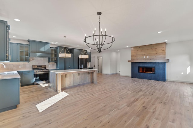 7284 205th St W, Faribault, MN 55021 - kitchen featuring stainless steel gas stove, recessed lighting, open floor plan, black fridge with ice dispenser, and light countertops