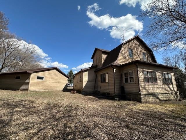 rear view of property with a gambrel roof