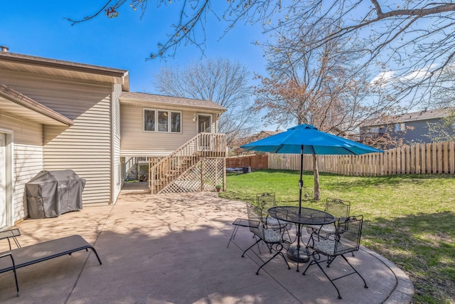 view of patio with outdoor dining area, fence, and a grill