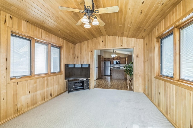carpeted living room featuring wooden walls, wooden ceiling, a ceiling fan, and vaulted ceiling