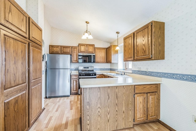 kitchen featuring appliances with stainless steel finishes, light wood-style floors, a peninsula, wallpapered walls, and vaulted ceiling