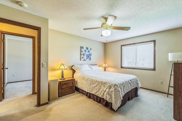 bedroom with a ceiling fan, baseboards, light colored carpet, and a textured ceiling