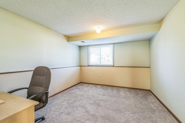 unfurnished office with carpet floors, a textured ceiling, and baseboards