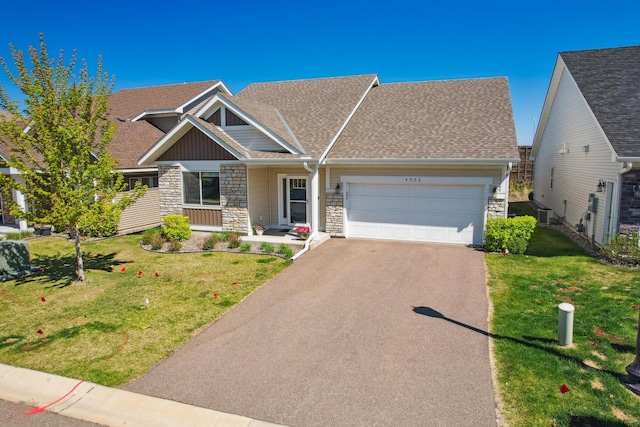 4922 93rd Way N, Brooklyn Park, MN 55443 - view of front of property with stone siding, asphalt driveway, an attached garage, and a front lawn