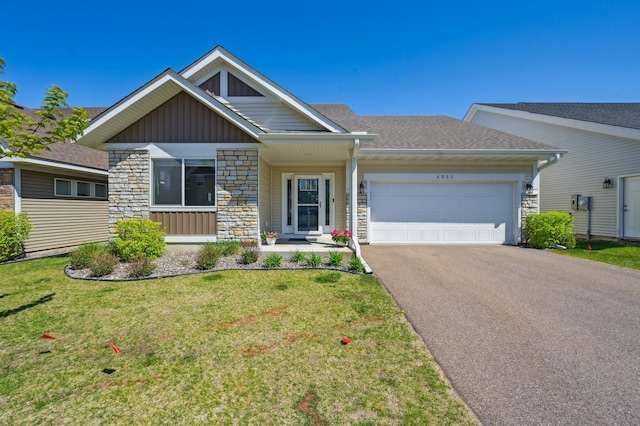 4922 93rd Way N, Brooklyn Park, MN 55443 - view of front facade featuring board and batten siding, stone siding, driveway, a garage, and a front yard
