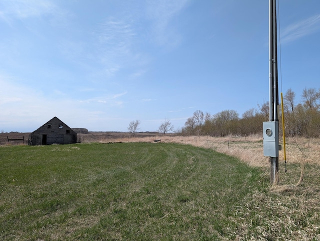 view of yard with a rural view, a barn, and an outdoor structure