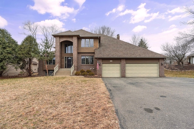 traditional-style home with a garage, aphalt driveway, brick siding, and a chimney