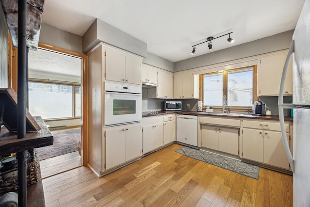 463 Minnesota St S, Stillwater, MN 55003 - kitchen with white appliances, a sink, light wood-type flooring, and dark countertops