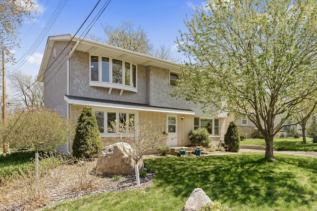 traditional-style home with stucco siding, brick siding, and a front lawn