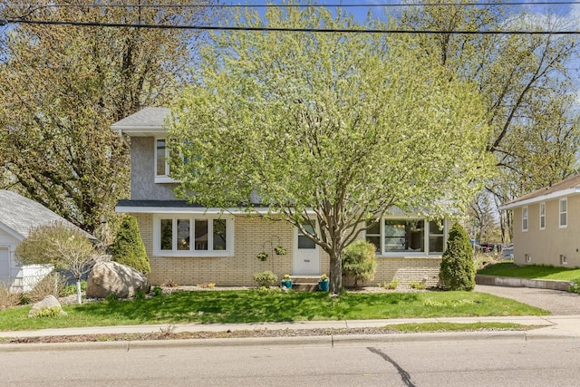 view of front of house featuring a front yard and brick siding