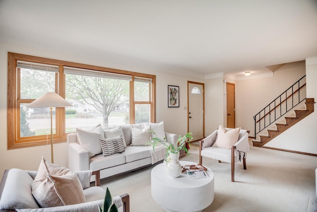 carpeted living room featuring stairs
