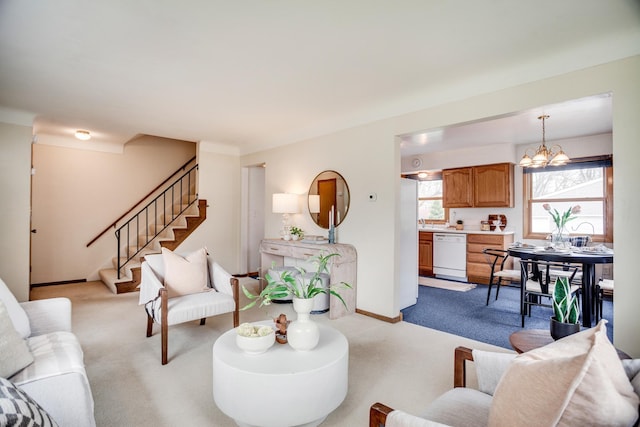carpeted living area with stairway, a notable chandelier, and baseboards