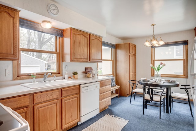 kitchen featuring a sink, decorative light fixtures, dishwasher, light countertops, and dark carpet