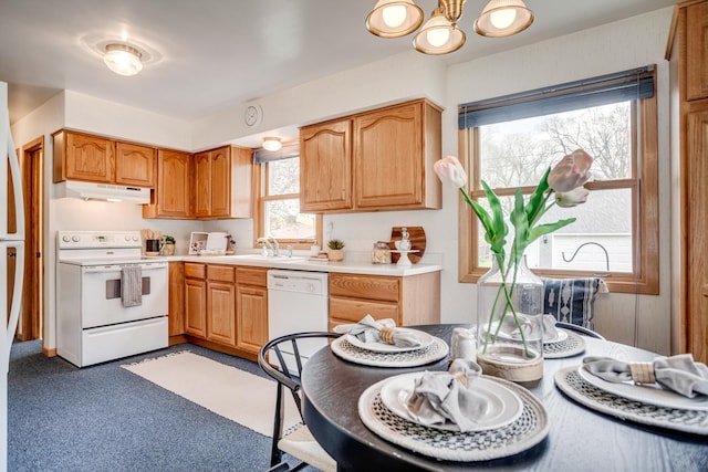 kitchen featuring white appliances, light countertops, a chandelier, and under cabinet range hood
