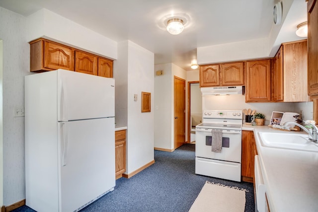 kitchen with a sink, white appliances, under cabinet range hood, dark colored carpet, and light countertops
