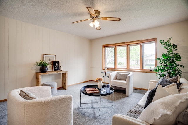 carpeted living room with a ceiling fan, baseboards, and a textured ceiling