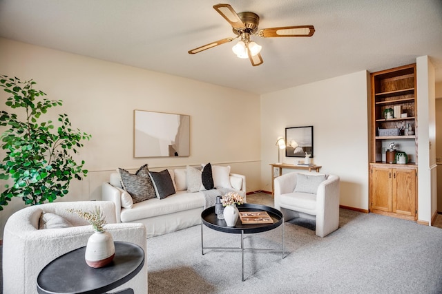 living area with baseboards, ceiling fan, and carpet floors