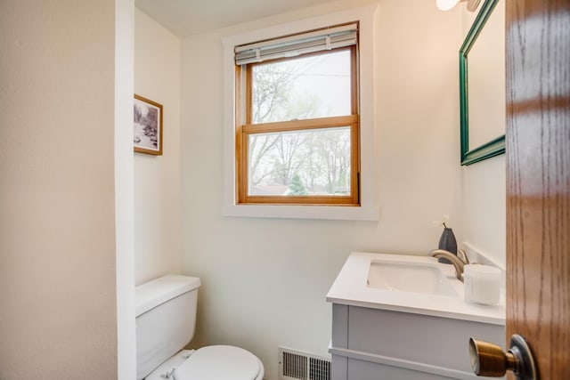 bathroom with vanity, toilet, and visible vents