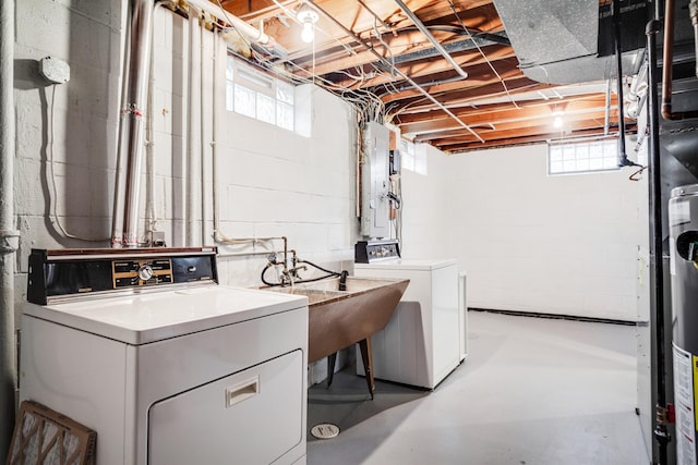 washroom featuring washer and clothes dryer, laundry area, electric panel, and a healthy amount of sunlight