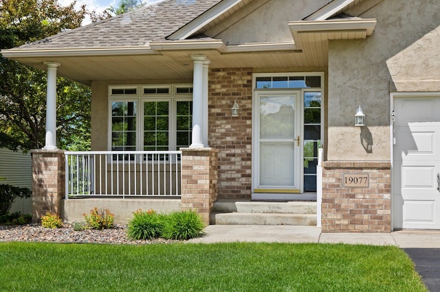 19077 Inman Trl, Lakeville, MN 55044 - doorway to property with a porch, brick siding, stucco siding, and a shingled roof