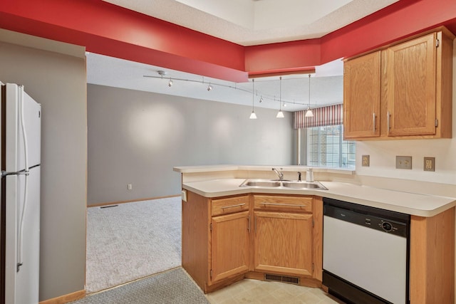 kitchen with light countertops, visible vents, a sink, white appliances, and a peninsula