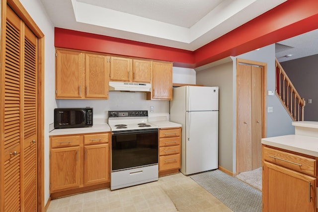 kitchen featuring black microwave, range with electric stovetop, light countertops, under cabinet range hood, and freestanding refrigerator