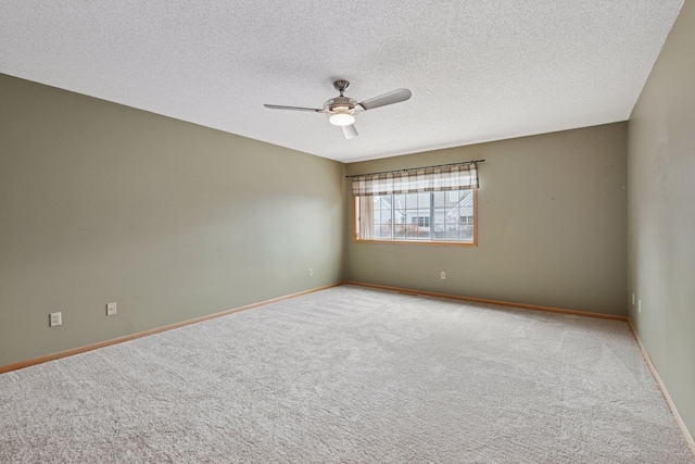 carpeted empty room featuring a ceiling fan, baseboards, and a textured ceiling