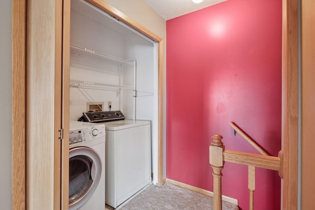 clothes washing area with light colored carpet, baseboards, washer and dryer, and laundry area