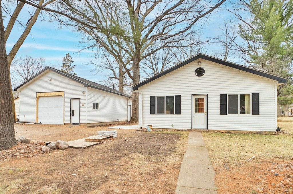 bungalow-style house with a garage and an outdoor structure