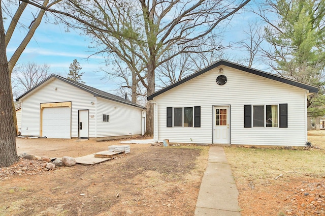 bungalow-style house with a garage and an outdoor structure