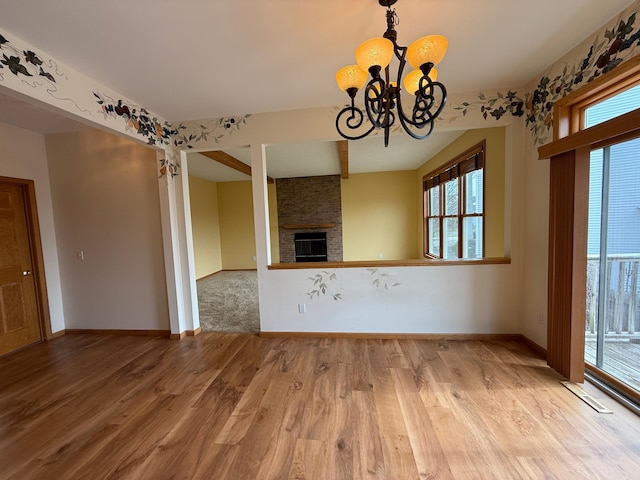 937 Briar Glen Ln, Woodbury, MN 55129 - unfurnished living room featuring wood finished floors, a chandelier, baseboards, and a brick fireplace