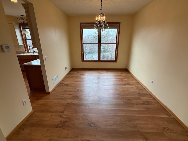937 Briar Glen Ln, Woodbury, MN 55129 - unfurnished dining area with a chandelier, healthy amount of natural light, and wood finished floors