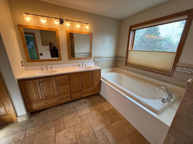 937 Briar Glen Ln, Woodbury, MN 55129 - full bathroom with a textured ceiling, a bath, double vanity, and stone tile floors