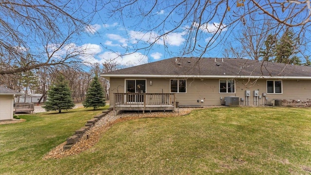 rear view of house with a lawn, a wooden deck, and cooling unit