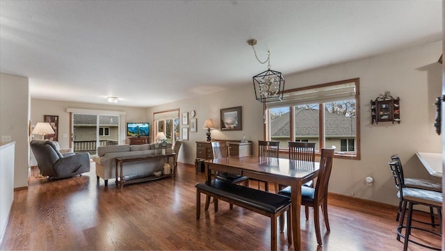 dining room featuring baseboards, wood finished floors, and a chandelier