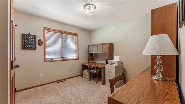 carpeted office space with visible vents and baseboards