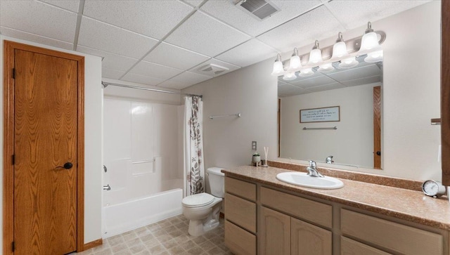 bathroom featuring visible vents, vanity, toilet, shower / bathtub combination with curtain, and a paneled ceiling