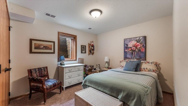bedroom featuring visible vents, carpet flooring, a textured ceiling, and baseboards