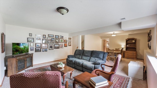 living area with carpet flooring, stairs, and visible vents