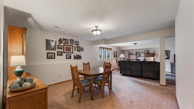 dining area with baseboards, visible vents, and light carpet