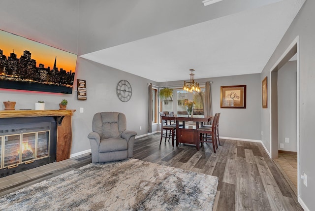 dining space with baseboards, wood finished floors, and a notable chandelier