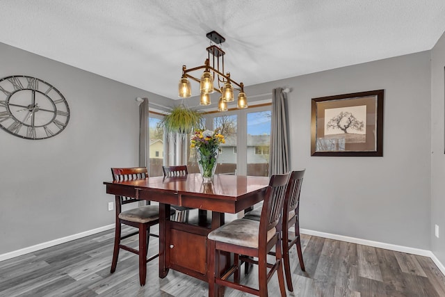 dining area featuring baseboards, dark wood-style floors, and a textured ceiling